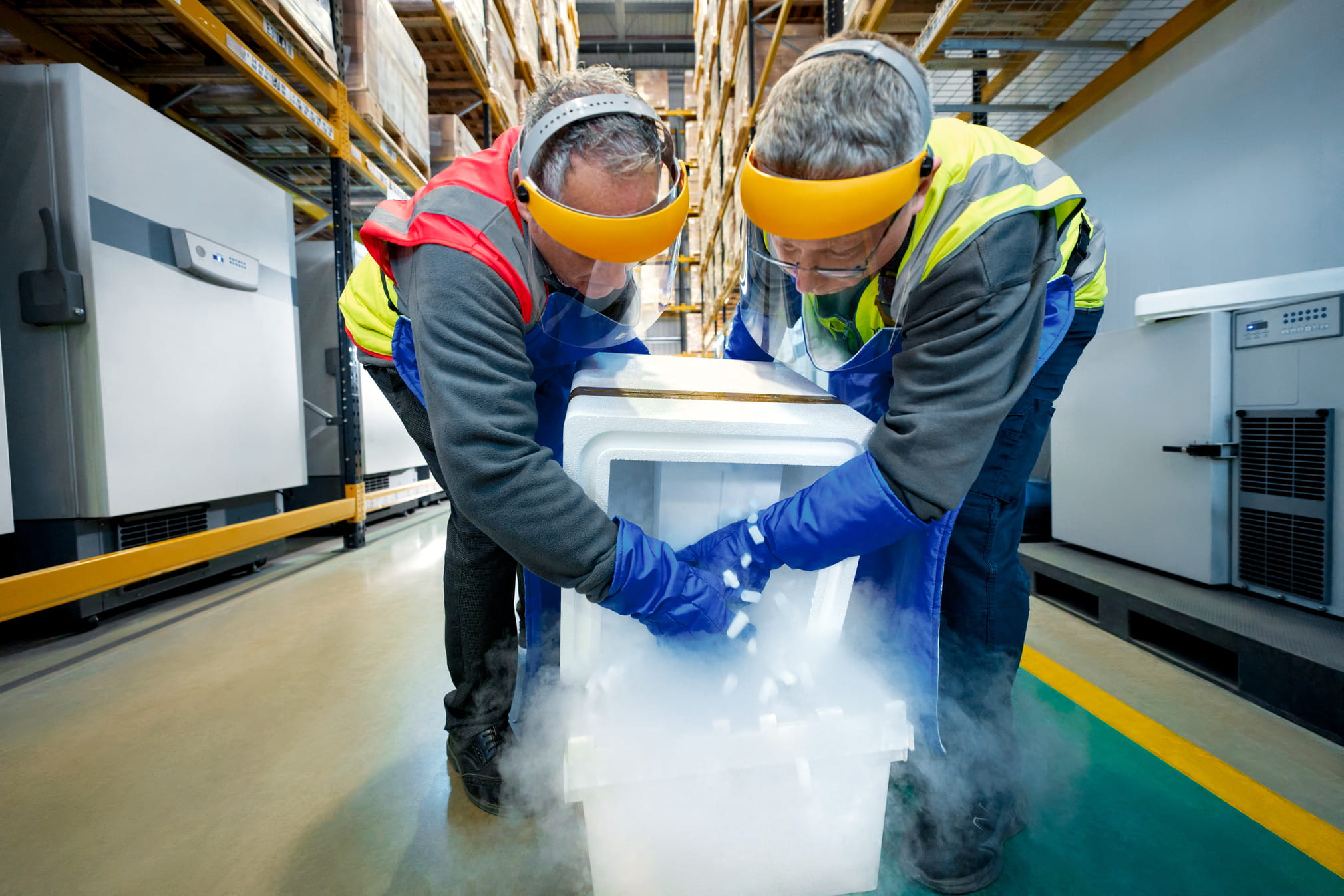 Warehouse operators pouring dry ice into deep-frozen packaging