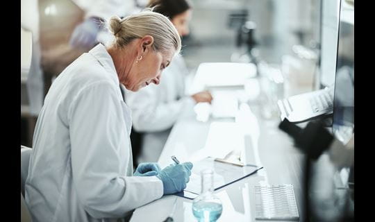 Woman researcher writing note on pad