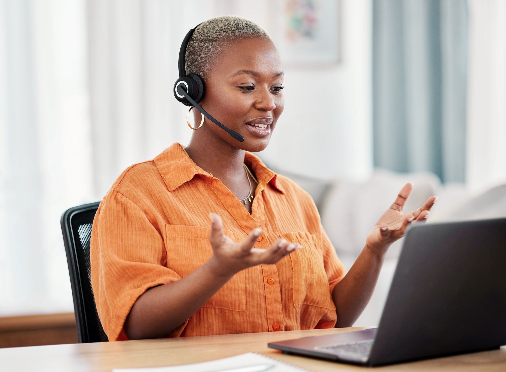 World Courier Cencora customer care specialist with laptop and headset speaking with a client 