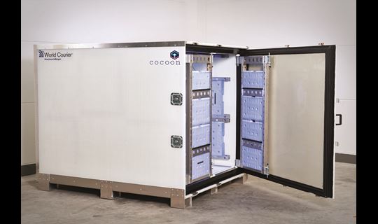 A cocoon shipping unit sits with its door open. Cooling gel packs are visible on the internal frame.